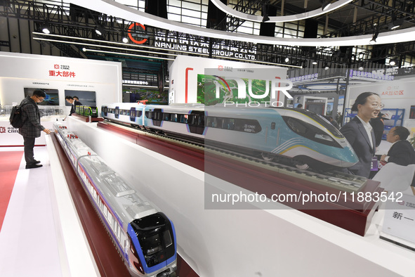 People visit a model EMU train on display at the World Intelligent Manufacturing Conference 2024 in Nanjing, China, on December 20, 2024. 