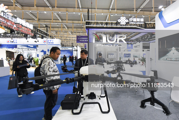 People visit a drone on display at the World Intelligent Manufacturing Conference 2024 in Nanjing, China, on December 20, 2024. 