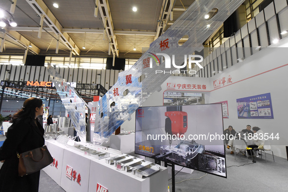 People visit a flying wing device on display at the World Intelligent Manufacturing Conference 2024 in Nanjing, China, on December 20, 2024....