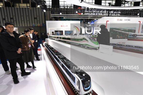 People visit a model EMU train on display at the World Intelligent Manufacturing Conference 2024 in Nanjing, China, on December 20, 2024. 