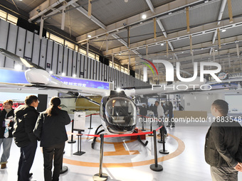 People visit a vertical drone on display at the World Intelligent Manufacturing Conference 2024 in Nanjing, China, on December 20, 2024. (