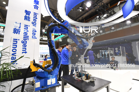 People visit and exhibit industrial robots at the 2024 World Intelligent Manufacturing Conference in Nanjing, Jiangsu Province, China, on De...