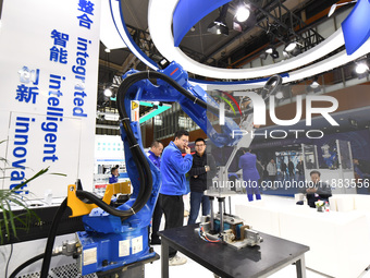 People visit and exhibit industrial robots at the 2024 World Intelligent Manufacturing Conference in Nanjing, Jiangsu Province, China, on De...