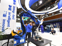 People visit and exhibit industrial robots at the 2024 World Intelligent Manufacturing Conference in Nanjing, Jiangsu Province, China, on De...