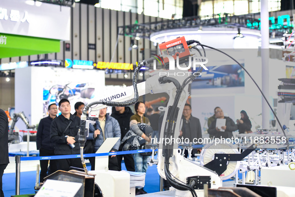 People visit and exhibit industrial robots at the 2024 World Intelligent Manufacturing Conference in Nanjing, Jiangsu Province, China, on De...