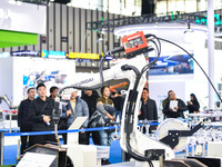 People visit and exhibit industrial robots at the 2024 World Intelligent Manufacturing Conference in Nanjing, Jiangsu Province, China, on De...