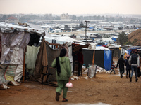 Displaced Palestinians walk in the rain at a makeshift camp in Khan Yunis, Gaza Strip, on December 20, 2024, amid the ongoing war between Is...