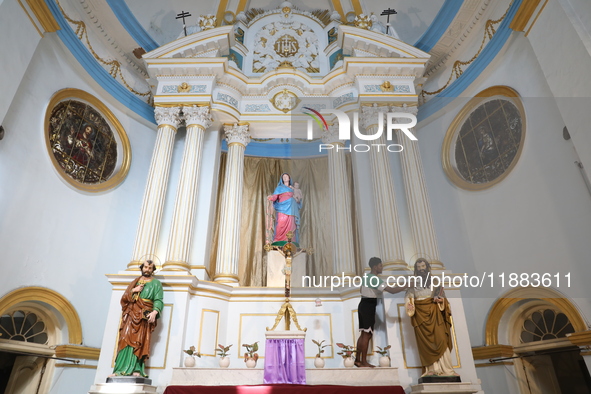 A worker cleans a statue inside a church in Kolkata, India, on December 20, 2024, ahead of Christmas celebrations. 