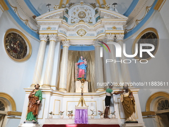 A worker cleans a statue inside a church in Kolkata, India, on December 20, 2024, ahead of Christmas celebrations. (