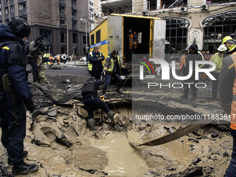 Experts examine a crater caused by a Russian missile strike in central Kyiv, Ukraine, on December 20, 2024. (