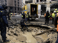 Experts examine a crater caused by a Russian missile strike in central Kyiv, Ukraine, on December 20, 2024. (