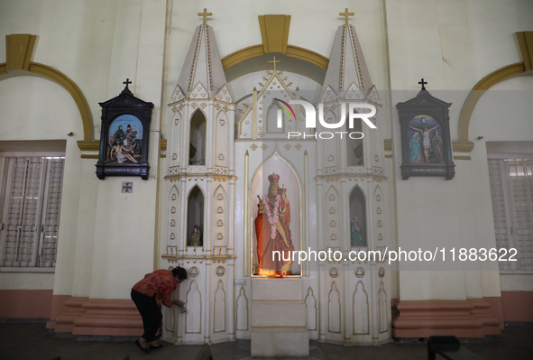 A woman cleans a statue inside a church in Kolkata, India, on December 20, 2024, ahead of Christmas celebrations. 