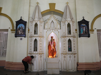 A woman cleans a statue inside a church in Kolkata, India, on December 20, 2024, ahead of Christmas celebrations. (