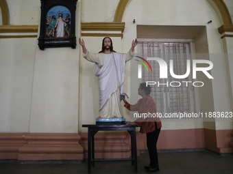 A woman cleans a statue of Jesus Christ inside a church in Kolkata, India, on December 20, 2024, ahead of Christmas celebrations. (