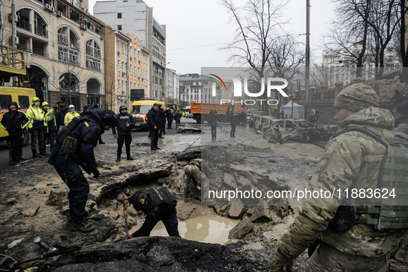 Experts examine a crater caused by a Russian missile strike in central Kyiv, Ukraine, on December 20, 2024. 