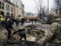 Experts examine a crater caused by a Russian missile strike in central Kyiv, Ukraine, on December 20, 2024. (