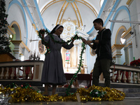 A nun and a worker decorate a church ahead of Christmas celebrations in Kolkata, India, on December 20, 2024. (