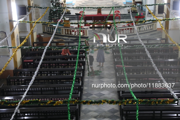 A nun and a worker decorate a church ahead of Christmas celebrations in Kolkata, India, on December 20, 2024. 