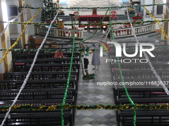 A nun and a worker decorate a church ahead of Christmas celebrations in Kolkata, India, on December 20, 2024. (