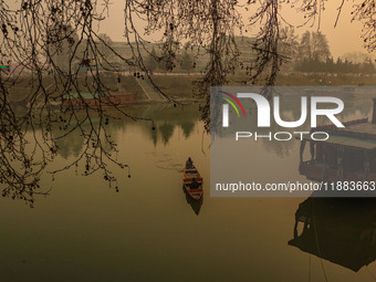 A man rows a boat on the waters of the Jhelum River in Srinagar, Jammu and Kashmir, on December 20, 2024. Kashmir remains in the grip of a c...