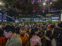 Visitors celebrate after artificial snow fills the Christmas decoration outside a shopping mall in Kuala Lumpur, Malaysia, on December 19, 2...