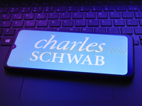 The Charles Schwab Corporation logo appears on a smartphone screen in this illustration photo in Reno, United States, on December 20, 2024....