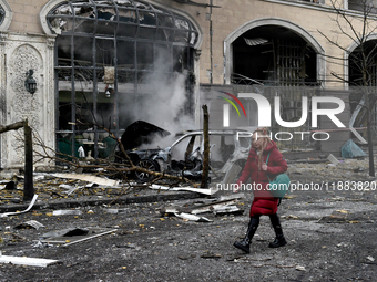 A woman walks along a street in the Holosiivskyi district covered with rubble after a Russian missile attack in Kyiv, Ukraine, on December 2...