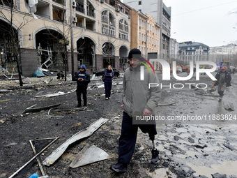 A man with a prosthetic leg walks along a street in the Holosiivskyi district covered with debris after a Russian missile attack in Kyiv, Uk...