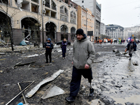 A man with a prosthetic leg walks along a street in the Holosiivskyi district covered with debris after a Russian missile attack in Kyiv, Uk...