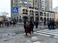 A woman crosses the street near a building in the Holosiivskyi district damaged by a Russian missile attack in Kyiv, Ukraine, on December 20...