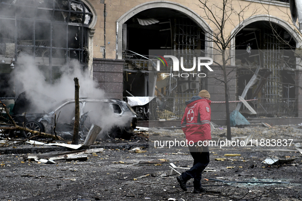 A Ukrainian Red Cross Society worker walks along a street in the Holosiivskyi district covered with rubble after a Russian missile attack in...