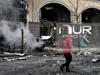 A Ukrainian Red Cross Society worker walks along a street in the Holosiivskyi district covered with rubble after a Russian missile attack in...