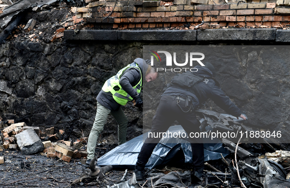 Police officers examine the debris in the Holosiivskyi district after a Russian missile attack in Kyiv, Ukraine, on December 20, 2024. On Fr...