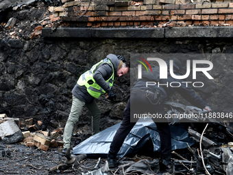 Police officers examine the debris in the Holosiivskyi district after a Russian missile attack in Kyiv, Ukraine, on December 20, 2024. On Fr...