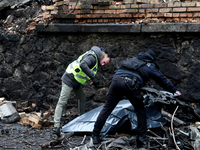 Police officers examine the debris in the Holosiivskyi district after a Russian missile attack in Kyiv, Ukraine, on December 20, 2024. On Fr...