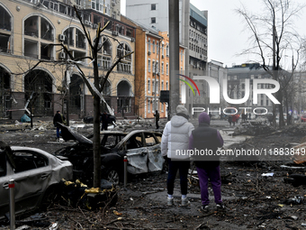 People look at damage caused by a Russian missile attack in the Holosiivskyi district, Kyiv, capital of Ukraine, on December 20, 2024. On Fr...