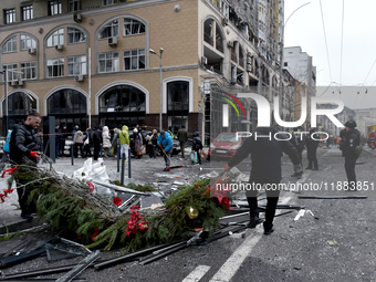 In Kyiv, Ukraine, on December 20, 2024, men remove Christmas decorations from the street in the Holosiivskyi district affected by a Russian...