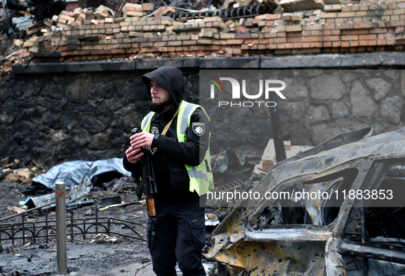 A police officer stands in the street in the Holosiivskyi district affected by a Russian missile attack in Kyiv, Ukraine, on December 20, 20...