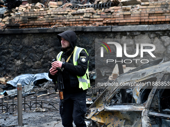 A police officer stands in the street in the Holosiivskyi district affected by a Russian missile attack in Kyiv, Ukraine, on December 20, 20...