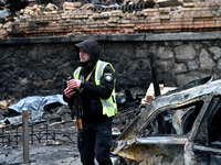 A police officer stands in the street in the Holosiivskyi district affected by a Russian missile attack in Kyiv, Ukraine, on December 20, 20...