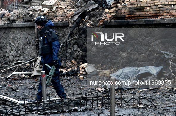 A police officer walks through the rubble in the Holosiivskyi district affected by a Russian missile attack in Kyiv, Ukraine, on December 20...