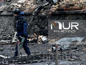 A police officer walks through the rubble in the Holosiivskyi district affected by a Russian missile attack in Kyiv, Ukraine, on December 20...