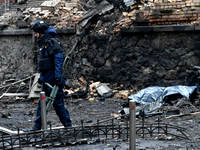 A police officer walks through the rubble in the Holosiivskyi district affected by a Russian missile attack in Kyiv, Ukraine, on December 20...