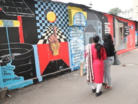 Women walk past a mural inside an alley during an open-air art festival, The Behala Art Fest, in Kolkata, India, on December 20, 2024. (