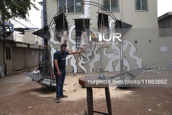 A man holds an art installation inside an alley during an open-air art festival, The Behala Art Fest, in Kolkata, India, on December 20, 202...