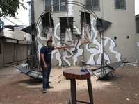 A man holds an art installation inside an alley during an open-air art festival, The Behala Art Fest, in Kolkata, India, on December 20, 202...