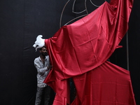 An artist works on a sculpture installed inside an alley during the open-air art festival, The Behala Art Fest, in Kolkata, India, on Decemb...