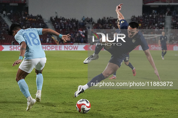 Seut Baraing of Cambodia competes against James Beresford of Thailand during the Mitsubishi Electric Cup 2004 Group A match between Thailand...