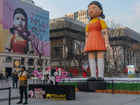 A person takes a photo in front of Young-hee, a robotic doll from Netflix's series ''Squid Game,'' at Gwanghwamun Square in Seoul, South Kor...