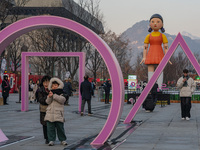 People take photos in front of Young-hee, a robotic doll from Netflix's ''Squid Game,'' at Gwanghwamun Square in Seoul, South Korea, on Dece...